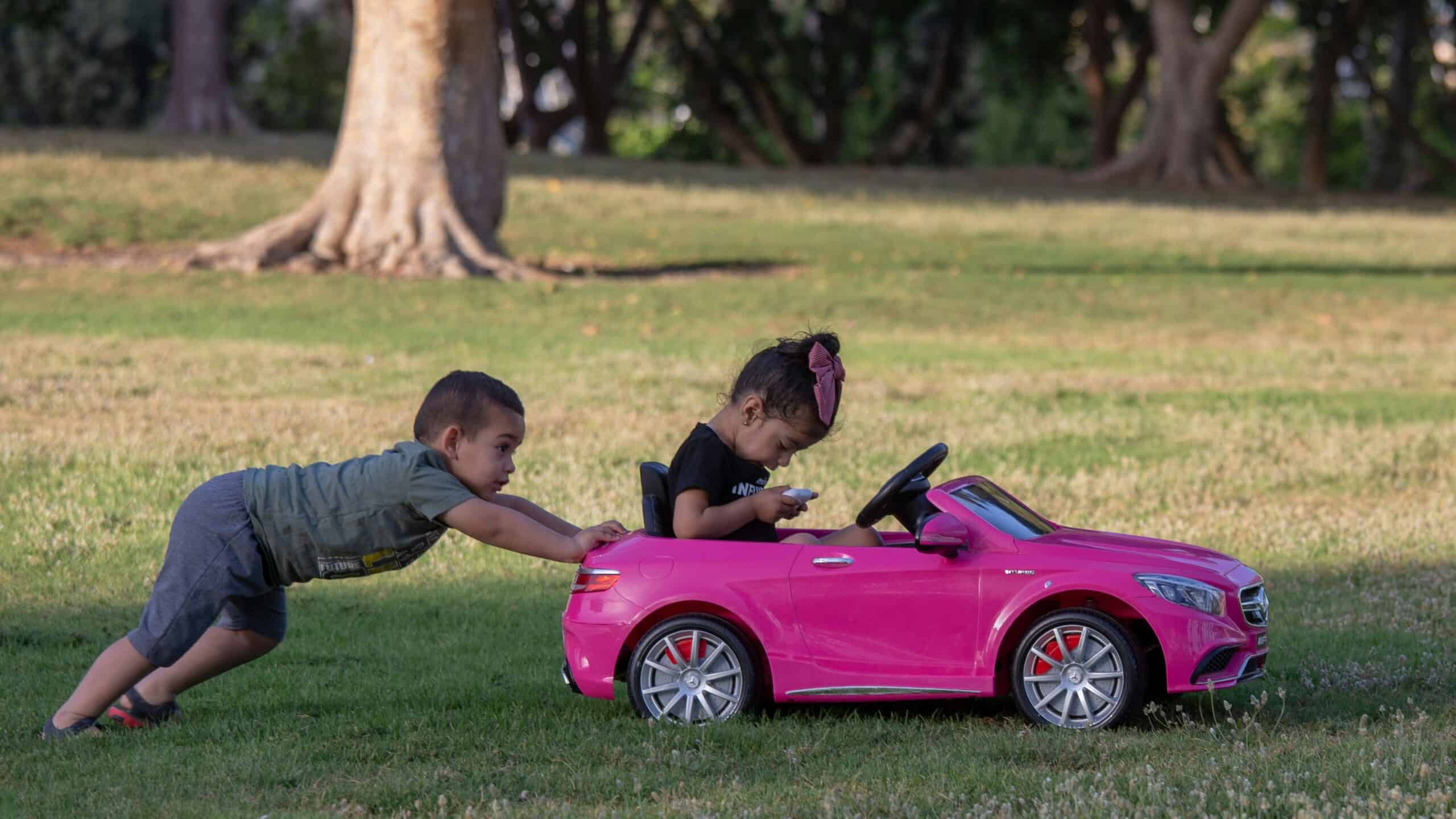 The Purchasing Power of Generation Alpha Kids: Influencing Family Car Buying Decisions 1 There is a girl in the toy car and the boy is pushing the car.